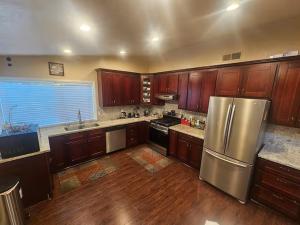 a kitchen with wooden cabinets and a stainless steel refrigerator at Urban Retreat -Suite A in San Jose