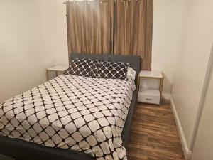 a bedroom with a bed with a black and white comforter at Urban Retreat -Suite A in San Jose