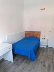 a bedroom with a bed with a blue bedspread at Appartamento Montevago Centro in Montevago