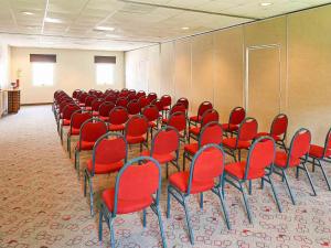 a room filled with red chairs in a classroom at Ibis Monterrey Aeropuerto in Monterrey