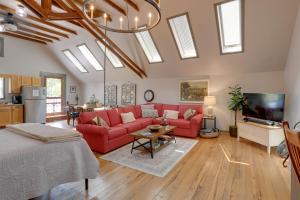 a living room with a red couch and a tv at Pet-Friendly Loft Vacation Rental w/ Fire Pit! in Bemus Point