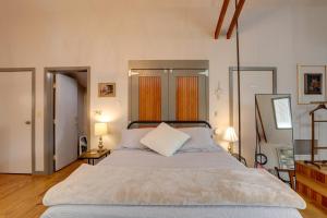 a bedroom with a large bed and two lamps at Pet-Friendly Loft Vacation Rental w/ Fire Pit! in Bemus Point