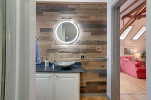 a bathroom with a wooden wall with a sink and a mirror at Pet-Friendly Loft Vacation Rental w/ Fire Pit! in Bemus Point +26 photos