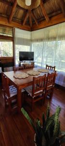a dining room with a table and chairs and a piano at Cabañas Manantiales de Obligado in San Pedro +27 photos