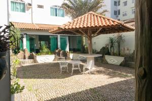 a patio with a table and chairs under an umbrella at Alzira Park Hotel Ltda in São Lourenço
