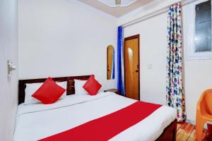a bedroom with a large bed with red pillows at Hotel O Ratiram in Kalkaji Devi