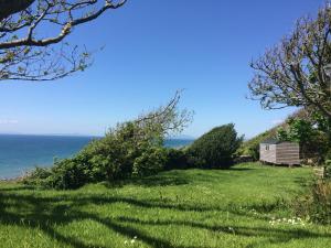 ein Haus auf einem Hügel neben dem Meer in der Unterkunft The Farm Hut in Barmouth