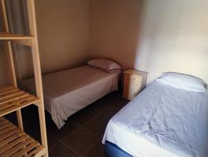 a small bedroom with two beds and a ladder at FiNCA DACA in Junín
