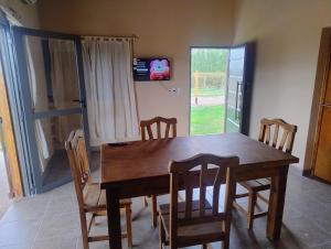 a dining room with a wooden table and chairs at FiNCA DACA in Junín
