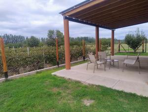 a pavilion with a table and chairs and a field at FiNCA DACA in Junín