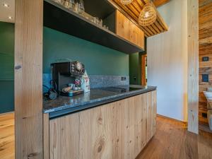 a kitchen with green walls and a counter top at Die Kramerei in Hollersbach im Pinzgau