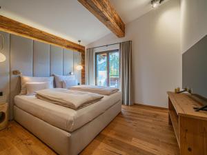 a bedroom with a large bed and a window at Die Kramerei in Hollersbach im Pinzgau