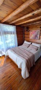 a large bed in a room with a wooden ceiling at Cabañas Manantiales de Obligado in San Pedro