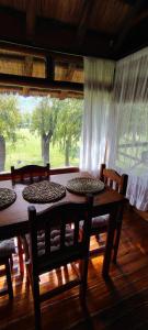 a wooden table and chairs in a room with a window at Cabañas Manantiales de Obligado in San Pedro