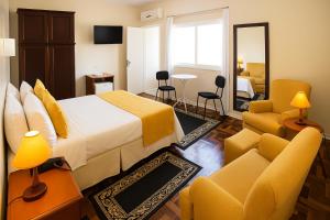 a hotel room with a bed and a living room at Hotel Ibiá in Montenegro