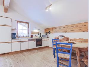 a kitchen with a wooden table and blue chairs at Igl Hof Top 4 in Westendorf +20 photos