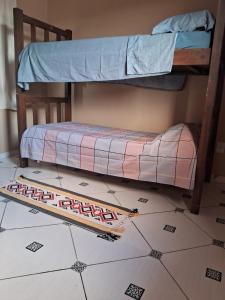 two bunk beds in a room with a rug on the floor at Casa 89 in Itacaré +4 photos