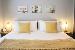 a bedroom with a bed with white sheets and yellow pillows at Dropper Post Bike Retreat Near OZ Trails & AMP in Rogers +67 photos