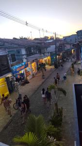 a group of people walking around a street with buildings at Casa 89 in Itacaré