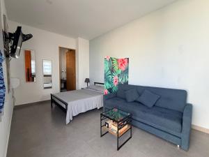 a living room with a couch and a bed at Atardeceres casa de playa in Cartagena de Indias