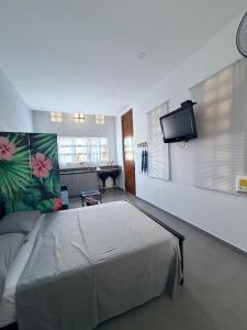 a bedroom with a bed and a flat screen tv at Atardeceres casa de playa in Cartagena de Indias