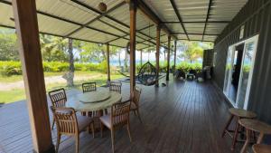 a porch with a table and chairs on it at One Piece in Golfito