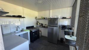 a small kitchen with a refrigerator and a sink at One Piece in Golfito