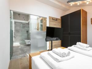 two beds in a room with a tv and a bathroom at Apart33 Top 1-33 Penthouse in Haus im Ennstal +58 photos