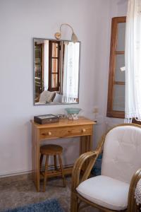 a desk with a mirror and a chair in a room at Traditional Mansion Kliaris in Ayía Kiriakí +45 photos