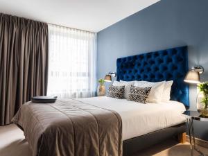 a bedroom with a large bed with a blue headboard at Mercure Lublin Centrum in Lublin