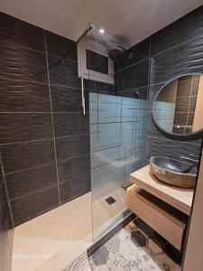 a bathroom with a sink and a mirror at JOLYKa résidence avec caméra et digicode possibilité location voiture Mercedes, garage ,climatisation ,cheminée, Netflix, petit déjeuner ,repas du soir fondue, raclette, barbecue sur demande in Albertville