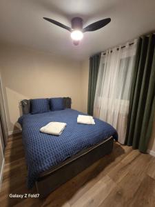 a bedroom with a bed with a ceiling fan at JOLYKa résidence avec caméra et digicode possibilité location voiture Mercedes, garage ,climatisation ,cheminée, Netflix, petit déjeuner ,repas du soir fondue, raclette, barbecue sur demande in Albertville