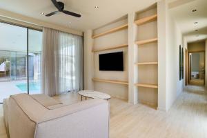 a living room with a couch and a flat screen tv at Villa Lavender by Villa Plus in Kolymbia