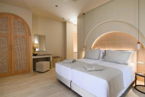 a bedroom with a large white bed and a table at Villa Lavender by Villa Plus in Kolymbia +23 photos