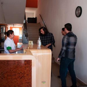 a group of people standing around a kitchen counter at Hotel Valle del Huajucar in Calvillo