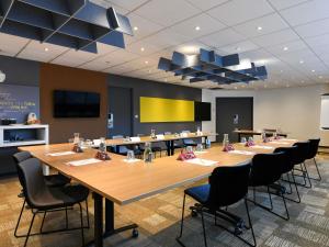 a conference room with a large wooden table and chairs at Hotel ibis Rennes Centre Gare Sud in Rennes