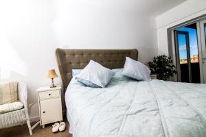 une chambre avec un lit, une chaise et une fenêtre dans l'établissement Farneholm Annex Cottage, à Beadnell
