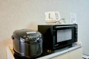 a microwave and a toaster sitting on a counter at Kvillage BLDG 無料駐車場付き 原爆ドームまで徒歩15分 大人数でもOK in Hiroshima