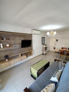 a living room with a blue couch and a tv at Depto céntrico de 3 habitaciones y cochera in Rosario