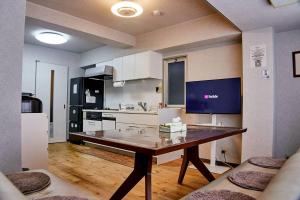 a kitchen with a table in the middle of a room at Kvillage BLDG 無料駐車場付き 原爆ドームまで徒歩15分 大人数でもOK in Hiroshima