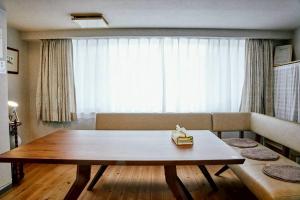 a living room with a table and a couch at Kvillage BLDG 無料駐車場付き 原爆ドームまで徒歩15分 大人数でもOK in Hiroshima