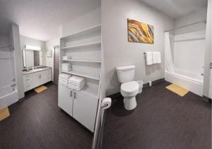 a white bathroom with a toilet and a sink at Golden Fern Escape in Des Moines +23 photos