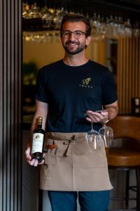 a man in an apron holding a bottle of wine at The Sofia Hotel in San Diego