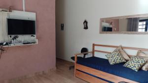 a bedroom with a bed and a tv on a wall at Rancho Macalé Balneário de Rancharia Sp in Rancharia