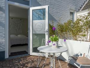 a patio with a table and a glass door at Duinsuite in Oostkapelle +16 photos