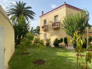 a house with a yard with trees and a building at Villa Sais avec piscine in Meknès