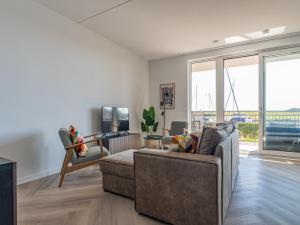 a living room with a couch and a tv at De Havenkamer in Kamperland