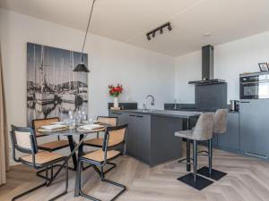 a kitchen with a table and chairs in a room at De Havenkamer in Kamperland