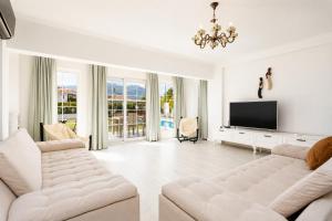 a living room with two white couches and a flat screen tv at Villa Crystal in Dalyan