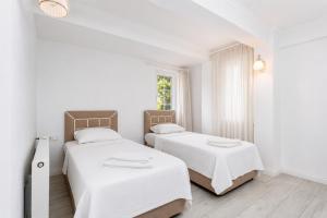 two beds in a bedroom with white walls and a window at Villa Crystal in Dalyan +11 photos